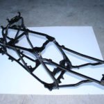 Motorcycle chassis frame on concrete floor.
