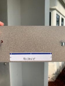 Metal plate with Mojave label, outside a building.