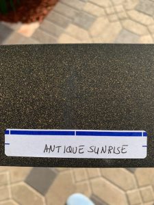 Brown granite sample labeled 'Antique Sunrise.'