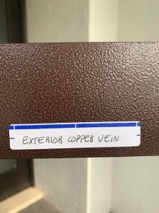Label on textured brown metal surface.