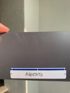 Gray sample labeled 'ARGENTO' held in hand