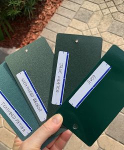 Four metal color samples held in hand.