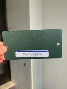 Hand holding green sample card labeled 'Jade Crater'.