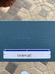 Blue box labeled Sapphire on textured floor.