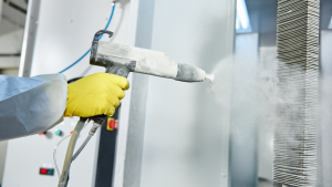 Worker spray painting with protective gear