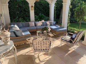 Elegant patio with blue cushioned furniture and orchids.