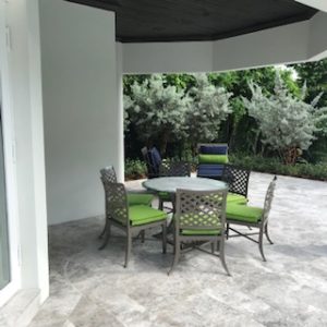 Outdoor patio with green cushioned chairs and table