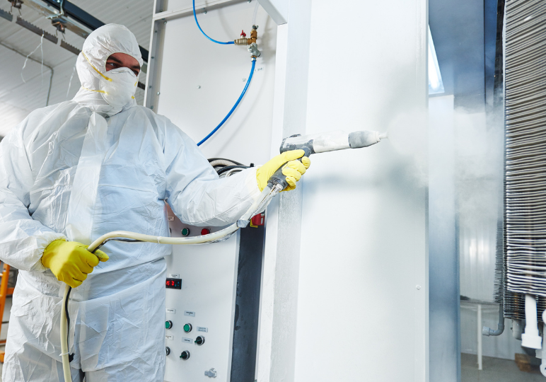 Worker in protective suit handling spray equipment