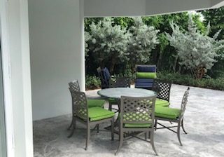 Outdoor patio with green cushioned chairs and table