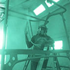 Person wearing helmet, working on metal structure